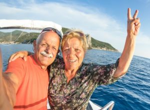 Adventurous senior couple taking travel selfie at Giglio Island