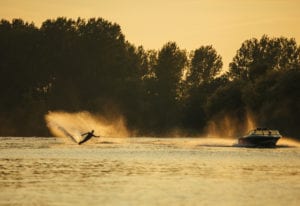 Carefree Boat Club Man wakeboarding on lake behind boat  