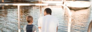 Father and son sitting water-front in San Diego Marina