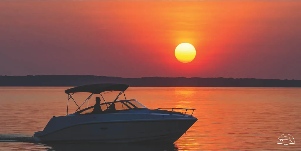 Sunset over Chesapeake Bay in Coastal Virginia with a boat cruising, Carefree Boat Club autumn evenings on the water