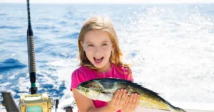 Young girl excited after catching a fish during a family boating trip in Coastal Virginia